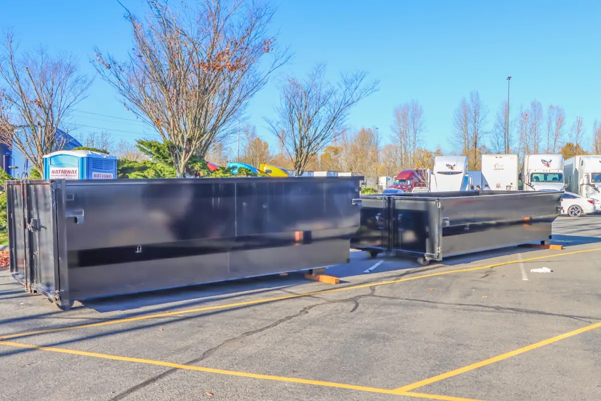 Professional dumpster rental service with roll-off container on residential driveway in Wall